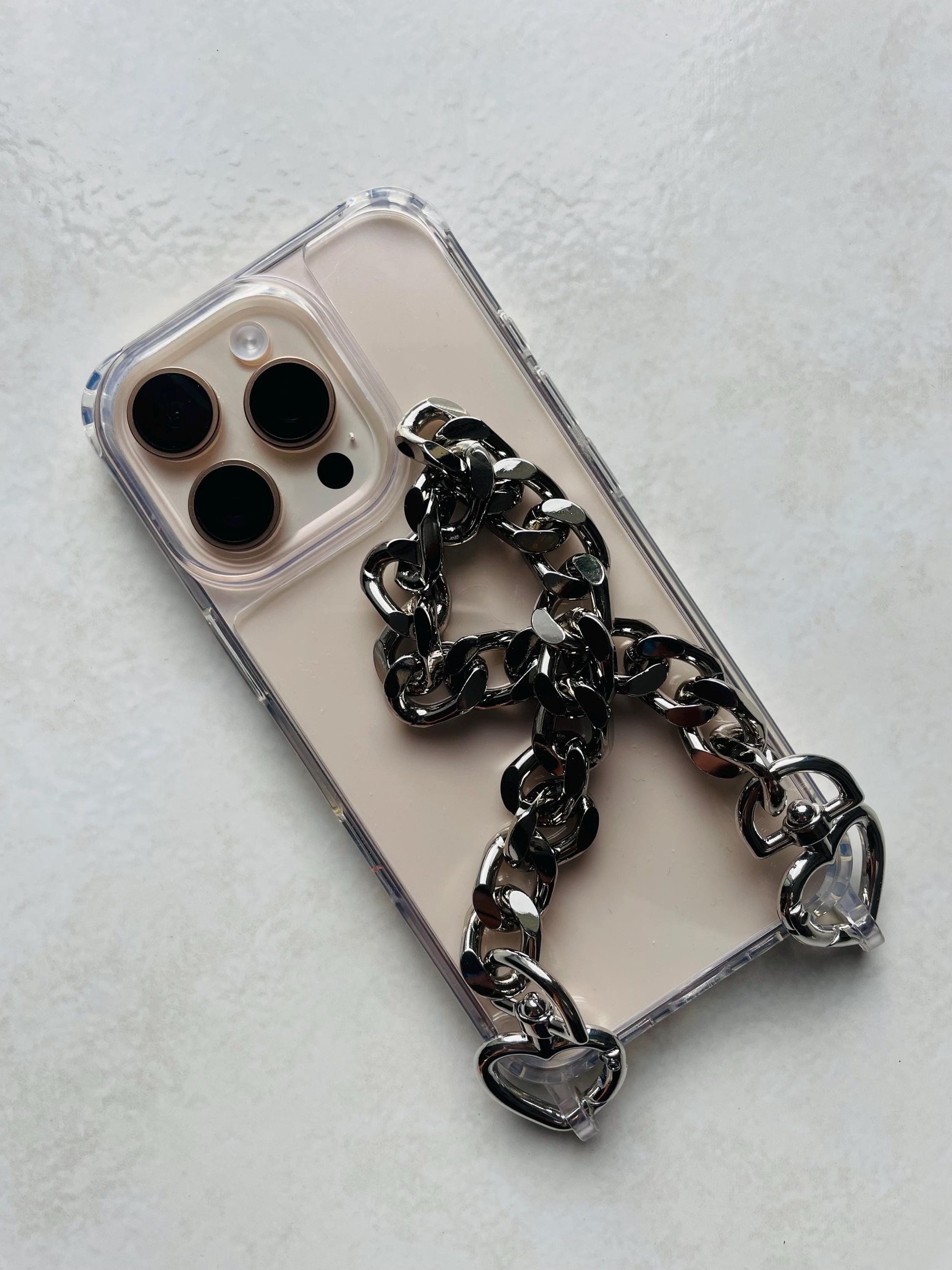 Coque téléphone transparente avec dragonne chaîne dorée – Maillons aluminium et attaches cœur – Accessoire chic et tendance