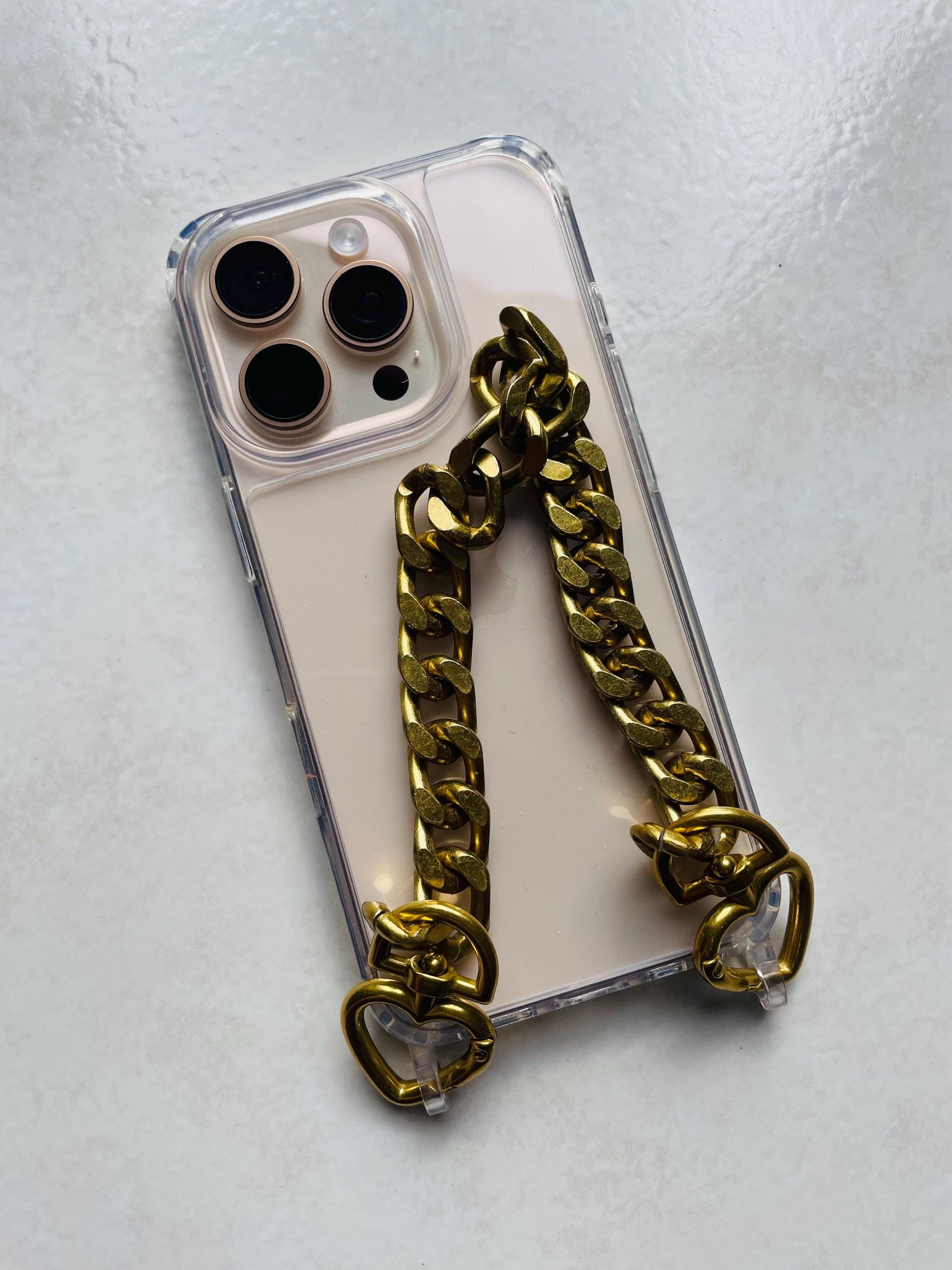 Coque téléphone transparente avec dragonne chaîne dorée – Maillons aluminium et attaches cœur – Accessoire chic et tendance